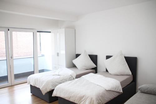 2 camas en una habitación con ventana en Casa Kronengarten Nr 4 en Hilden