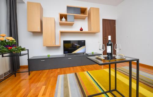 ein Wohnzimmer mit einem TV und einem Tisch mit einer Flasche Wein in der Unterkunft Residenza Don Pepito in Bukarest