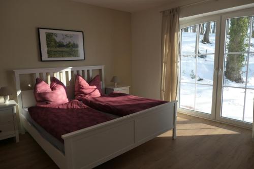 a bedroom with a bed with pink pillows on it at RZB Derboven - Bünkemühler Kuhliebe in Bücken