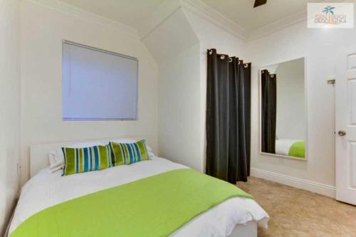 sypialnia z zielonym i białym łóżkiem i lustrem w obiekcie 199-surf Stars Combo w mieście San Diego
