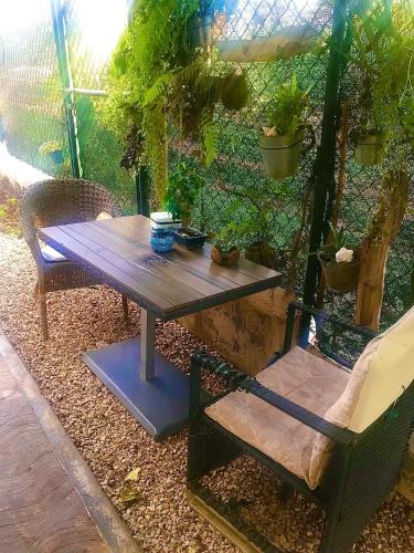 a wooden table and a bench with plants on it at ECOVILLA CORAL GARDEN in Baoruco