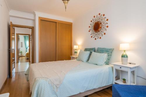 a bedroom with a bed and a mirror on the wall at Cozy and Stylish Beach Flat in Armação de Pêra