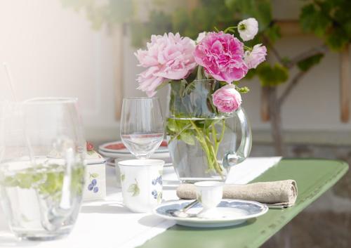a table with a vase with pink flowers on it at Gästehaus Schönitz in Meißen