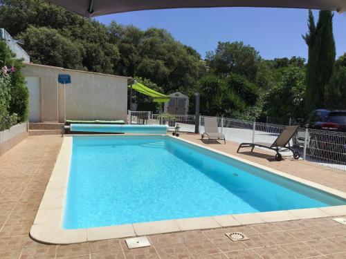 une grande piscine avec de l'eau bleue dans l'établissement Pavillon T2 proche ville dans petite résidence, à Cuttoli-Corticchiato