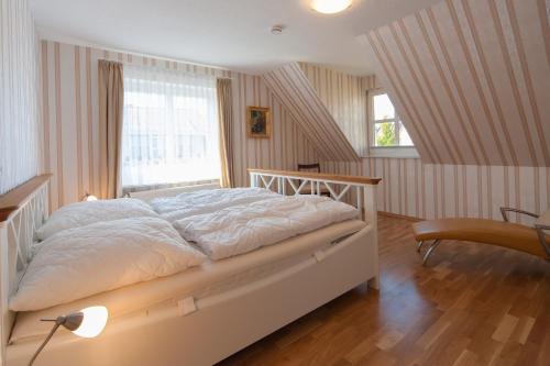 a bedroom with a large white bed and a window at Gustavs Apartment in Zingst