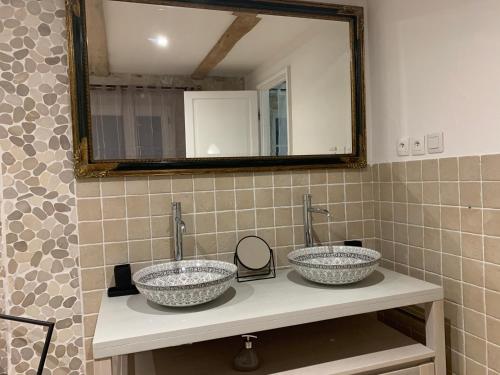 a bathroom with two sinks and a mirror at le mas des roses 1884 in Vence
