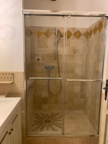 a shower with a glass door in a bathroom at le mas des roses 1884 in Vence
