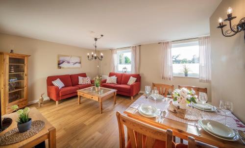 a living room with a table and a red couch at Backhaus West in Bisdorf