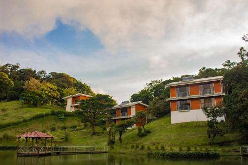a row of houses on a hill next to a lake at Burbi Lake Lodge Monteverde in Monteverde Costa Rica