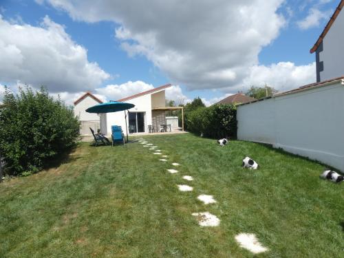 a yard with two dogs laying on the grass at gite de la libellule in Commentry