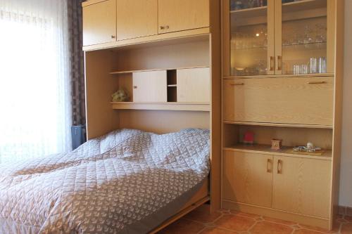 a bedroom with a bed and wooden shelves and cabinets at Ferienwohnung Baumert in Grömitz