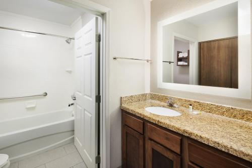 y baño con lavabo y espejo. en Staybridge Suites Of Durham - Chapel Hill - RTP, an IHG Hotel en Durham