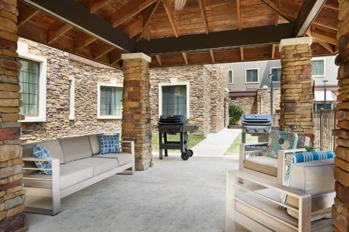 a patio with two couches and a grill at Staybridge Suites Of Durham - Chapel Hill - RTP by IHG in Durham