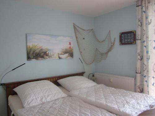 オストゼーバート・ディアーハーゲンにあるSeepferdchen App 11のベッドルーム1室(ベッド1台付)が備わります。壁に絵が飾られています。