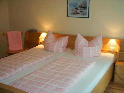 ハーゼリュンネにあるFerienhof Niemann Wohnung 7のベッドルーム1室(ピンクと白の枕が備わるベッド1台付)