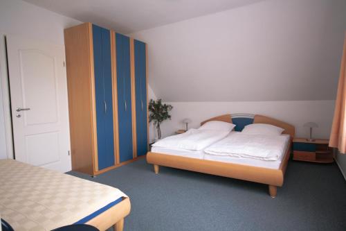 ヴァンガーオーゲにあるOsterdüne 68のベッドルーム1室(ベッド1台、青いキャビネット付)