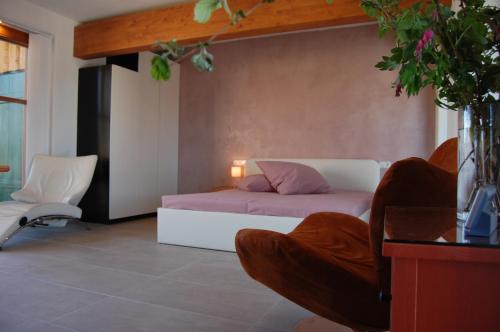 1 dormitorio con 1 cama y 1 silla en Studio Via Claudia Augusta, en Denklingen