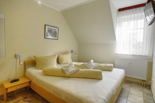 a bedroom with a large white bed with a window at Sonne, Whg 4 in Zingst