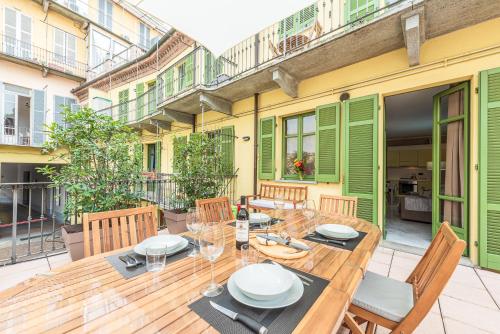 アルバにあるDiVino Holiday Apartmentsのパティオにある木製のテーブルと椅子
