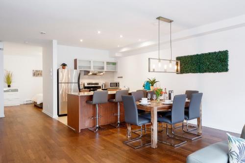 a dining room and kitchen with a table and chairs at Suite Mont-Royal by MTLVacationRentals in Montréal