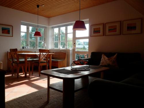 sala de estar con mesa, sofá y comedor en Landhaus-Marwede App 5 en Haffkrug