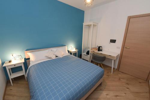 a blue bedroom with a bed and a desk at Geordie's in Potenza