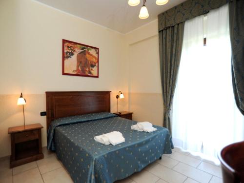 Säng eller sängar i ett rum på Hotel Il Melograno