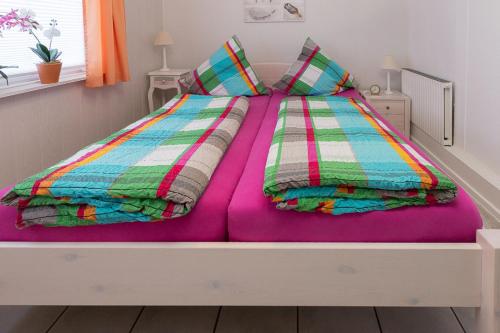 エッカーンフェルデにあるDaniel-Ferienhaus 1のベッド(紫の毛布と枕付)