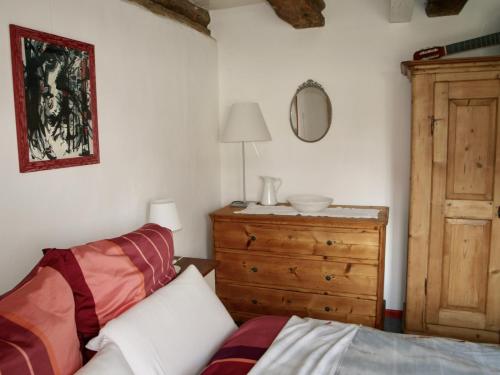 a bedroom with a bed and a dresser and a mirror at Die alte Kate in Tribohm