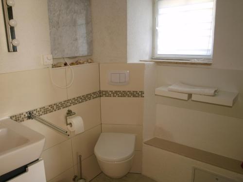 a bathroom with a toilet and a sink and a window at Die alte Kate in Tribohm