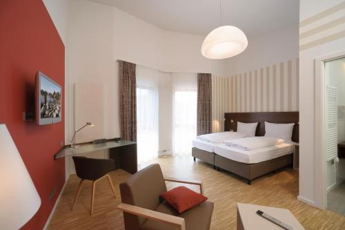 a bedroom with a bed and a living room at Seehörnle Bio Hotel & Gasthaus in Gaienhofen