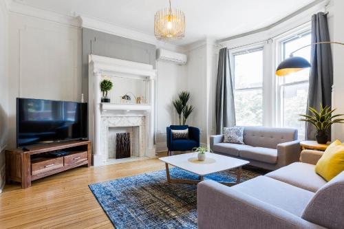 un soggiorno con un divano e una TV di MTLVacationRentals -The Chic Laurier a Montréal