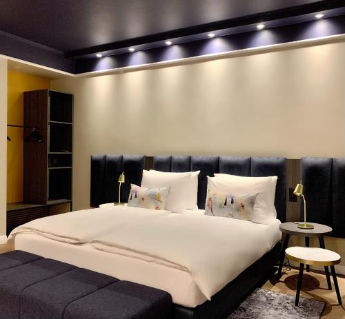 a bedroom with a large white bed with lights on it at Maison Viktoria Augsburg in Augsburg
