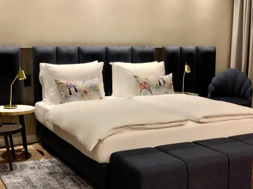 a bedroom with a large bed with white sheets and pillows at Maison Viktoria Augsburg in Augsburg
