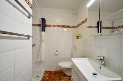 a white bathroom with a sink and a toilet at Bornholm Whg2 in Nieblum