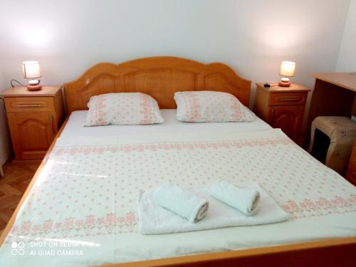 a bedroom with a bed with two towels on it at Guest House Ahmo Halilcevic in Dubrave Gornje