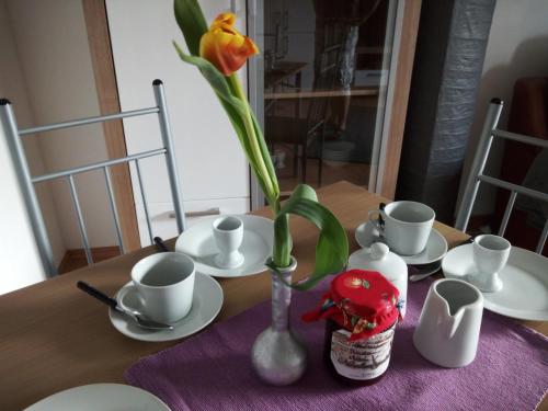 une table avec un vase avec une fleur dans l'établissement Ferienwohnung Margot in VS, à Villingen-Schwenningen