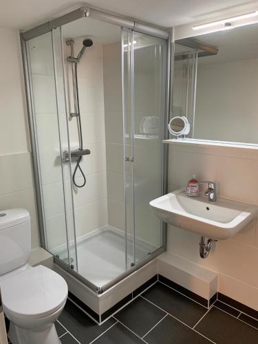 a bathroom with a shower and a toilet and a sink at Segellast 5 in Lübeck