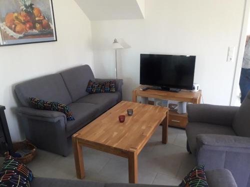 a living room with a couch and a table with a tv at Haus Linden in Hage