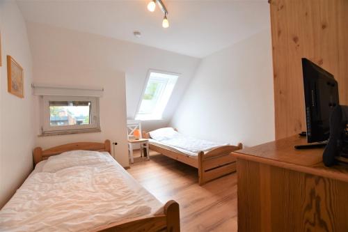 a bedroom with a bed and a tv in it at Haus Kamp in Dahme