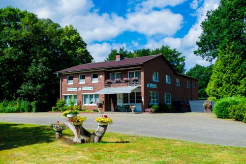 a large brick building with two vases of flowers at Gästezimmer 4 im Landgasthaus Lindenhof in Fresenburg