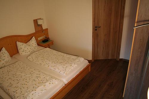 a small bedroom with a bed with a wooden headboard at Wallberg in Bad Wiessee