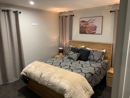 a bedroom with a bed with a wooden head board at Executive-style home away from home. in Hawera