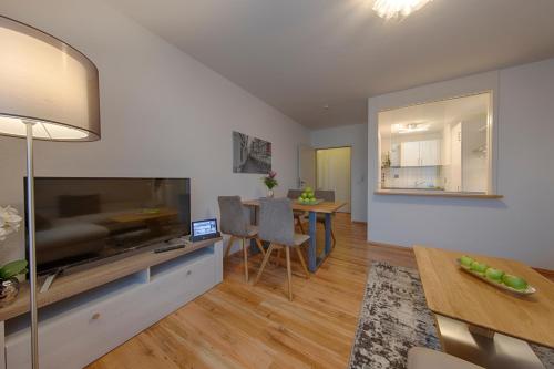 a living room with a television and a dining room at Appartement 48 Komfort in Wetzlar