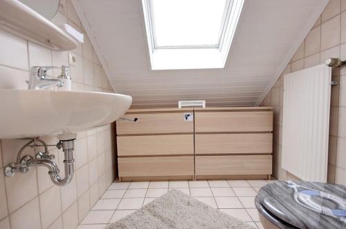 ディツムにあるFerienhaus Möweのバスルーム(洗面台、トイレ付)、窓が備わります。