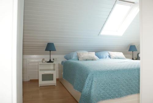 ディツムにあるFerienhaus Möweのベッドルーム1室(青いシーツと窓付)