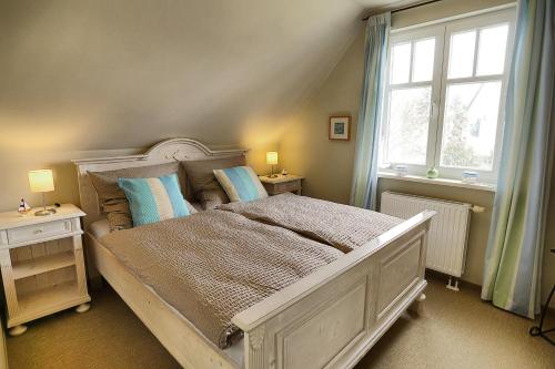 a bedroom with a large white bed with blue pillows at Werder in Zingst