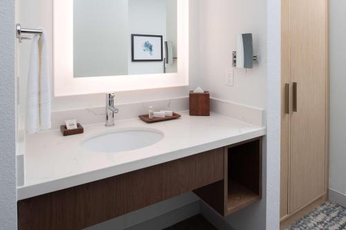 a bathroom with a sink and a mirror at Best Western Premier Keizer Salem Hotel in Keizer