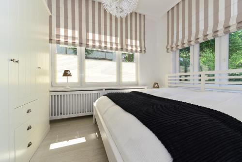 SüdstrandにあるHaus Störtebeckerの白いベッドルーム(ベッド1台、窓付)