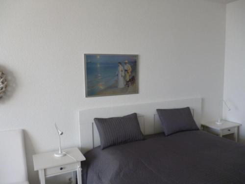 a bedroom with a bed and a picture on the wall at Fehmarn-OstseeferienFewoMarquardt165 in Burgtiefe auf Fehmarn 